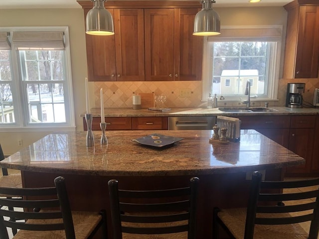 kitchen with a kitchen bar, brown cabinets, and a sink