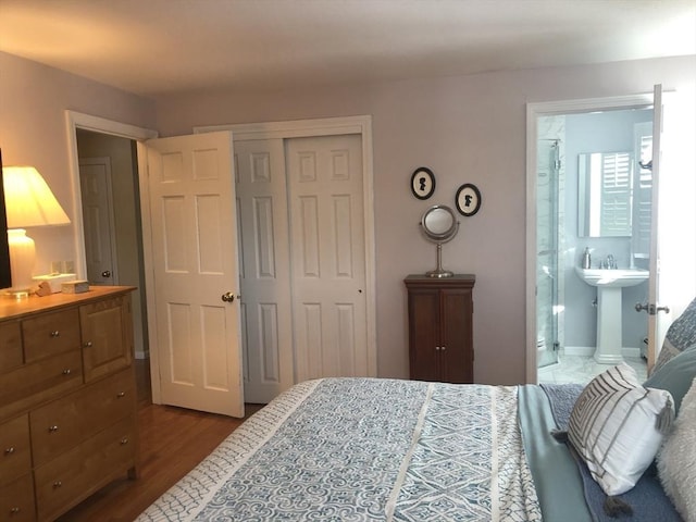 bedroom featuring a closet, connected bathroom, and wood finished floors