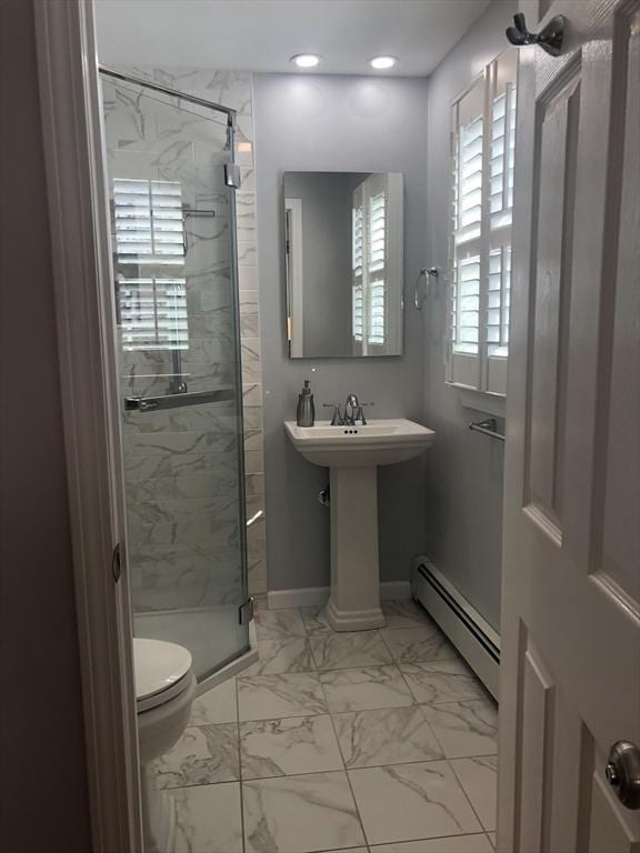 bathroom featuring marble finish floor, toilet, a baseboard heating unit, a shower stall, and baseboards