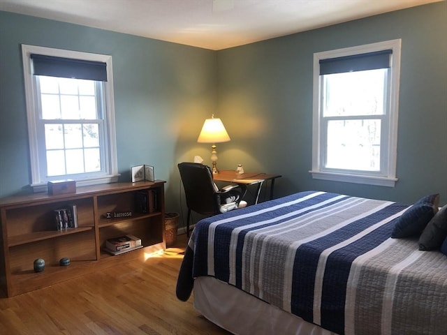 bedroom with multiple windows and wood finished floors