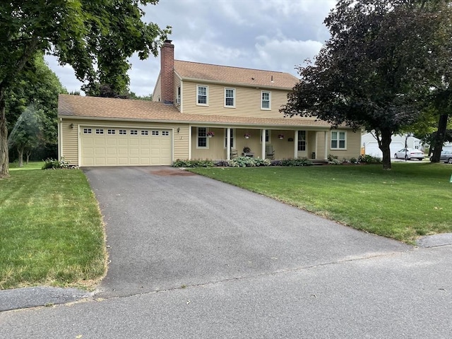 view of front facade featuring a garage, a chimney, aphalt driveway, a porch, and a front yard