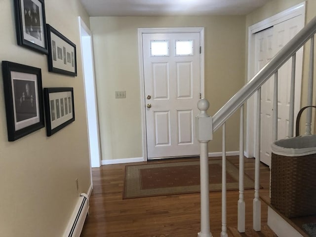 entrance foyer featuring a baseboard heating unit, baseboards, stairway, and dark wood-style flooring