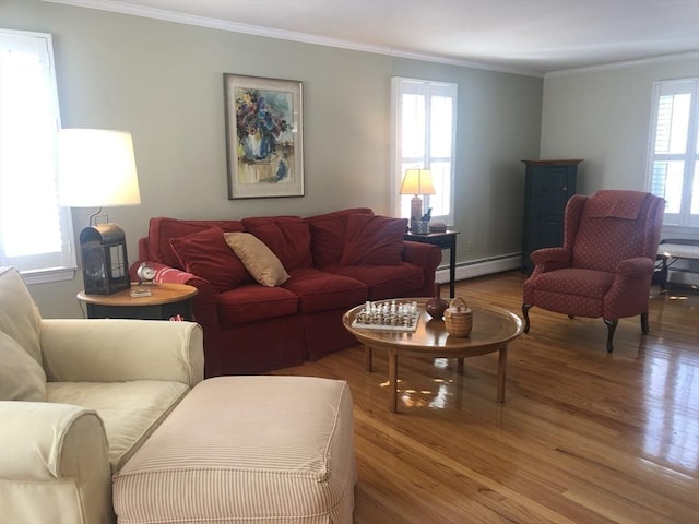 living room featuring baseboard heating, wood finished floors, and a healthy amount of sunlight