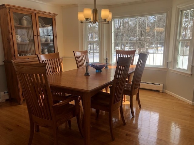 dining area featuring light wood finished floors, baseboards, baseboard heating, and an inviting chandelier