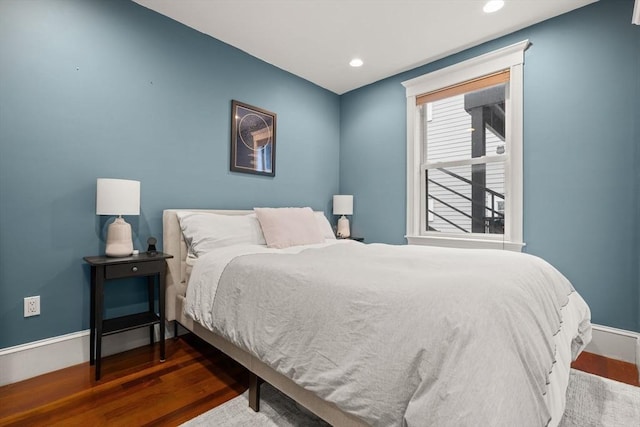 bedroom with wood finished floors, baseboards, and recessed lighting