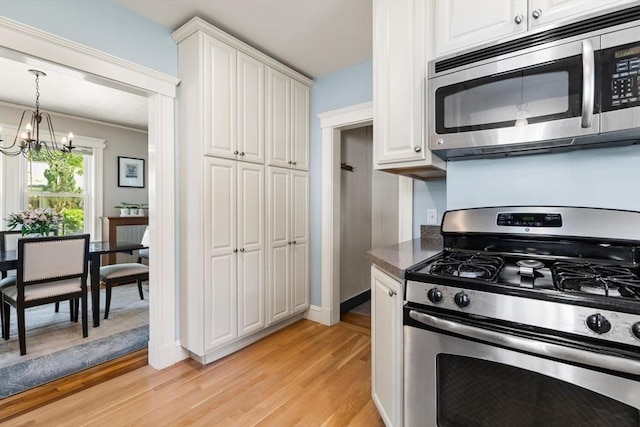 33 Lowell Ave, Watertown, MA 02472 - kitchen featuring stainless steel appliances, a chandelier, light wood finished floors, and white cabinets