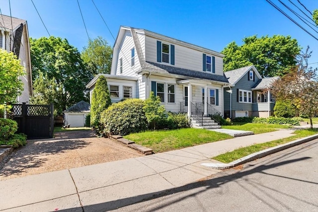 33 Lowell Ave, Watertown, MA 02472 - view of front facade featuring a gambrel roof, driveway, an outdoor structure, and a garage