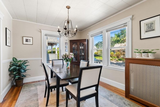 33 Lowell Ave, Watertown, MA 02472 - dining area with ornamental molding, a chandelier, wood finished floors, and baseboards
