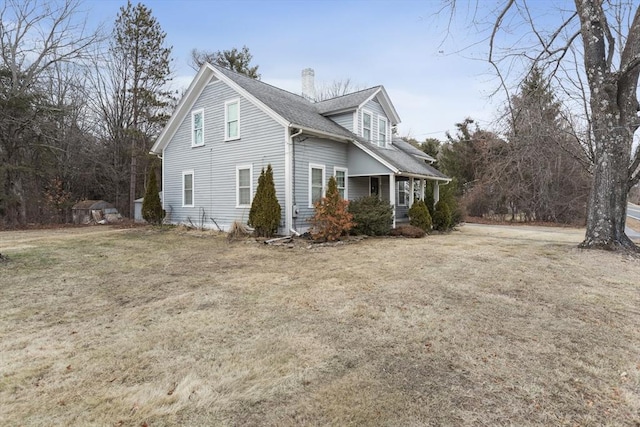 view of home's exterior featuring a porch and a yard