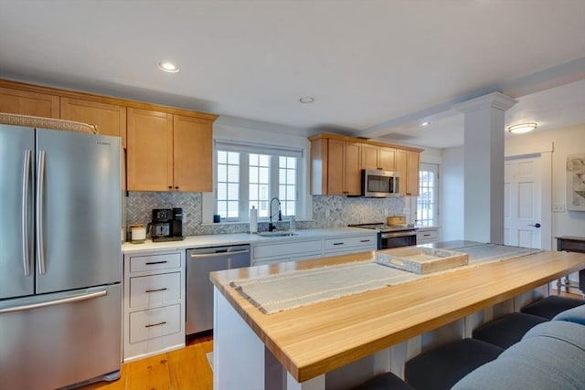 kitchen with stainless steel appliances, a center island, sink, and backsplash