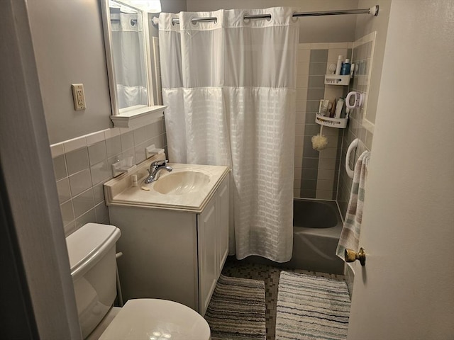 full bathroom with tile walls, toilet, shower / bath combination with curtain, and vanity