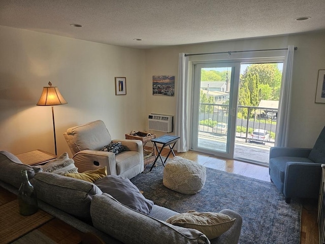 living room with wood finished floors, a textured ceiling, and cooling unit