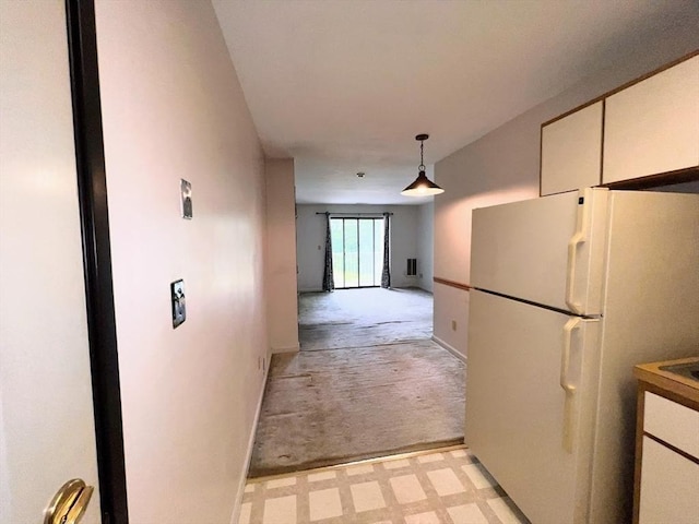 3 Bridgeview Cir Unit 55, Tyngsborough, MA 01879 - kitchen with freestanding refrigerator, light colored carpet, decorative light fixtures, and white cabinets