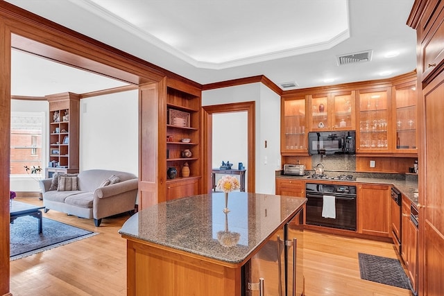 kitchen with black appliances, a kitchen island, light hardwood / wood-style floors, and crown molding