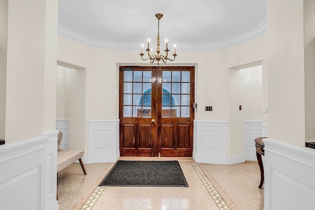 foyer entrance featuring ornamental molding and a chandelier