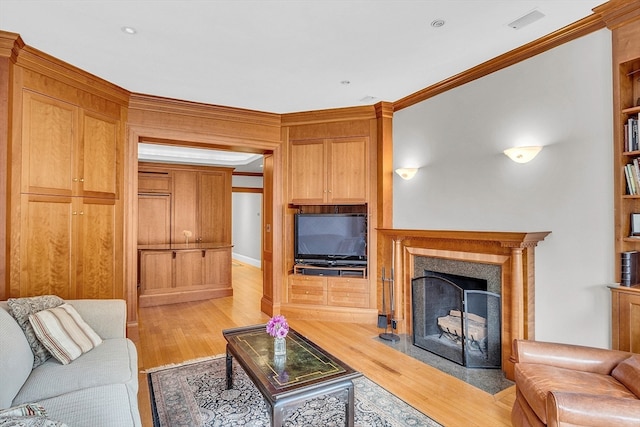 living room with crown molding and light hardwood / wood-style floors