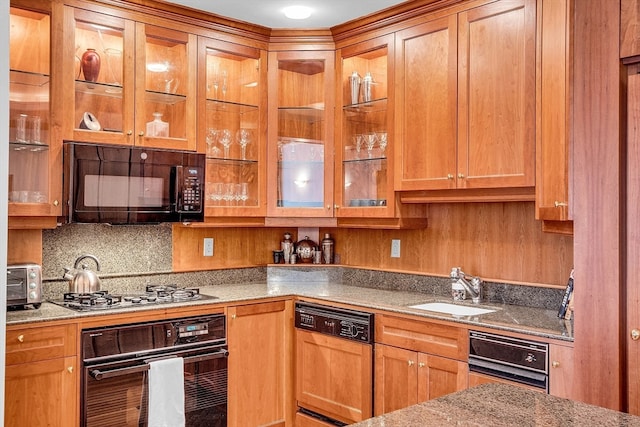 kitchen with black appliances, light stone counters, decorative backsplash, and sink