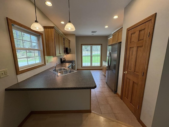 kitchen with decorative backsplash, dark countertops, a peninsula, stainless steel appliances, and recessed lighting