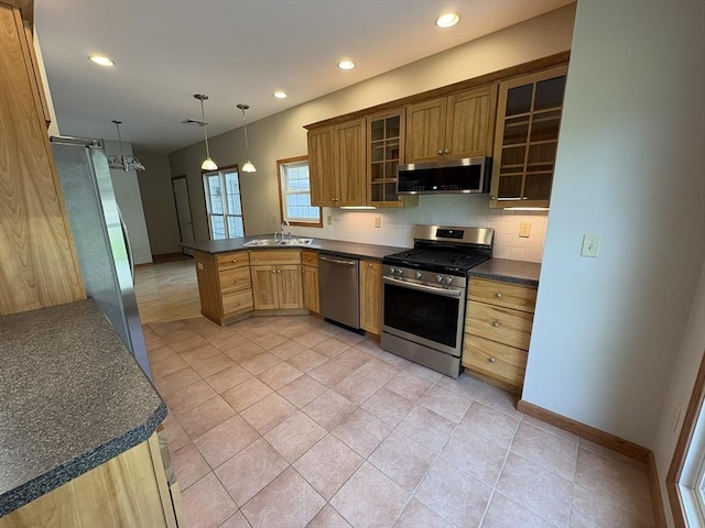 kitchen with dark countertops, stainless steel appliances, a peninsula, tasteful backsplash, and glass insert cabinets