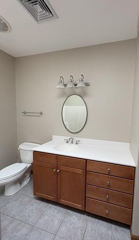 bathroom featuring vanity, tile patterned flooring, toilet, and visible vents