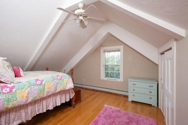 bedroom with vaulted ceiling, a baseboard heating unit, ceiling fan, and light hardwood / wood-style floors