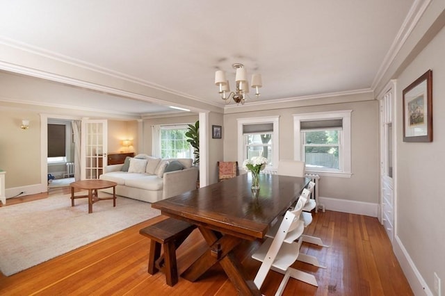 dining room with a chandelier, hardwood / wood-style floors, and ornamental molding