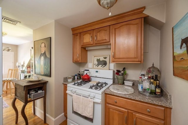 kitchen featuring light wood-type flooring and white range with gas stovetop