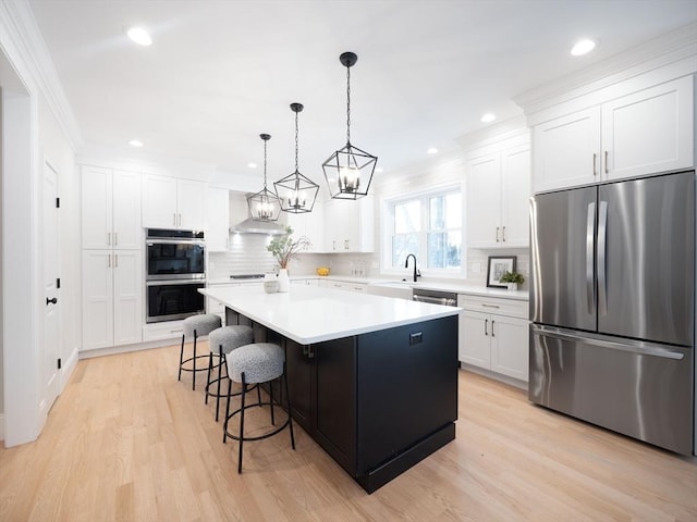 7 Brookdale Rd, Natick, MA 01760 - kitchen with white cabinetry, appliances with stainless steel finishes, a kitchen island, and wall chimney range hood
