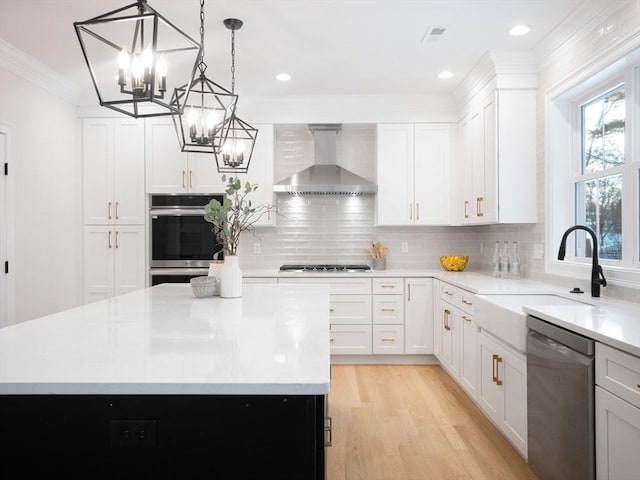 7 Brookdale Rd, Natick, MA 01760 - kitchen with an inviting chandelier, ornamental molding, a kitchen island, wall chimney range hood, and appliances with stainless steel finishes