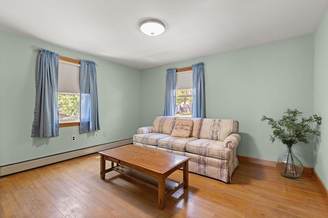 living room with wood-type flooring, a baseboard radiator, and baseboards