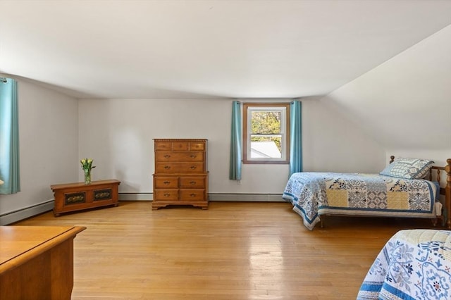 bedroom featuring a baseboard radiator, light wood-style floors, and vaulted ceiling