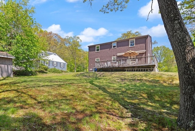 back of house featuring a wooden deck and a yard