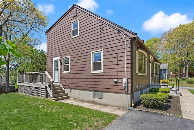 view of home's exterior with a yard and a deck