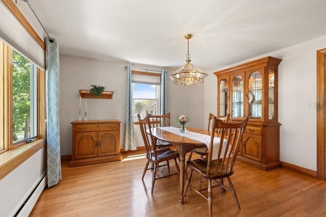 dining room featuring a baseboard radiator, plenty of natural light, a chandelier, and light wood finished floors