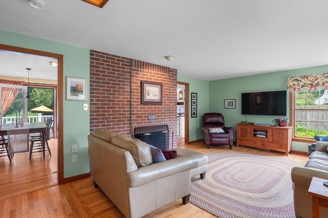 2 Dewey St, Amesbury, MA 01913 - living room featuring healthy amount of natural light, light wood-style floors, and a brick fireplace