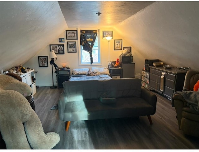 bedroom featuring vaulted ceiling, dark wood finished floors, and a textured ceiling