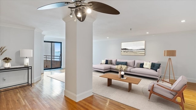 living room featuring ceiling fan, light hardwood / wood-style floors, and ornamental molding