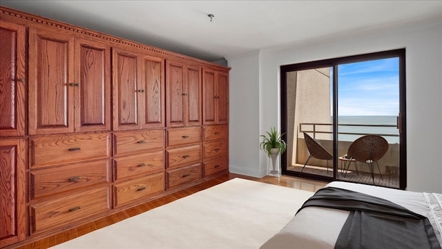 bedroom featuring light hardwood / wood-style flooring and a water view