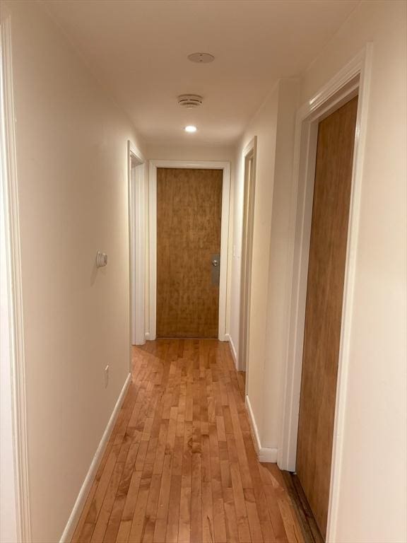 hall with baseboards and light wood-style floors