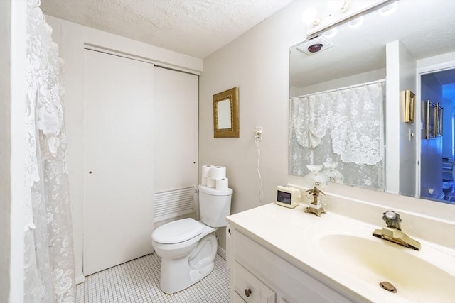 full bathroom featuring vanity, tile patterned floors, toilet, and a textured ceiling