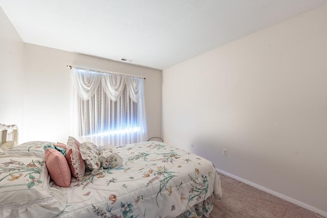 carpeted bedroom with visible vents and baseboards