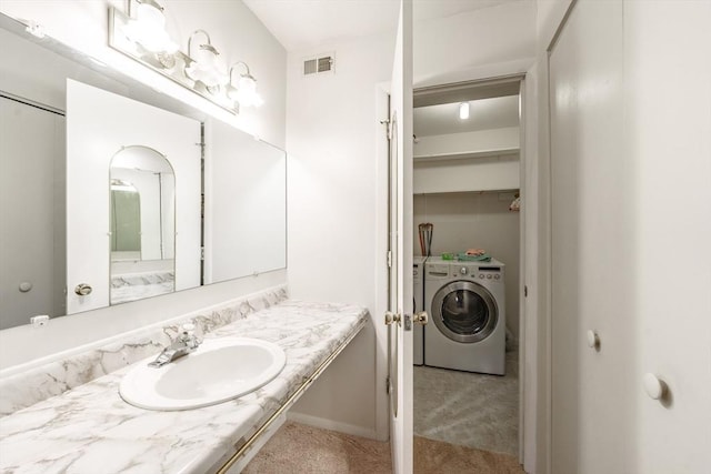 bathroom featuring visible vents, vanity, and washing machine and clothes dryer