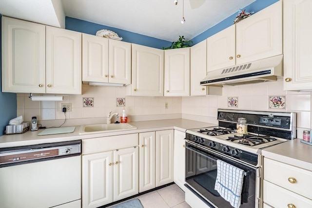 kitchen featuring white appliances, backsplash, under cabinet range hood, and a sink