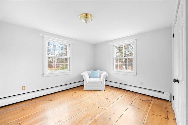 unfurnished room featuring baseboard heating and hardwood / wood-style flooring