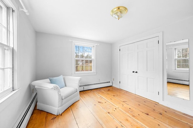 sitting room with light wood finished floors and a baseboard radiator