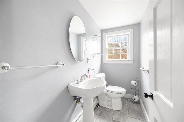 bathroom with toilet and baseboards