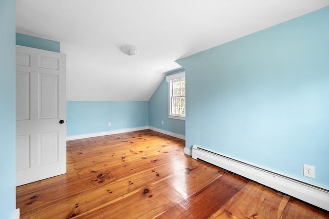 additional living space featuring lofted ceiling, wood-type flooring, a baseboard heating unit, and baseboards