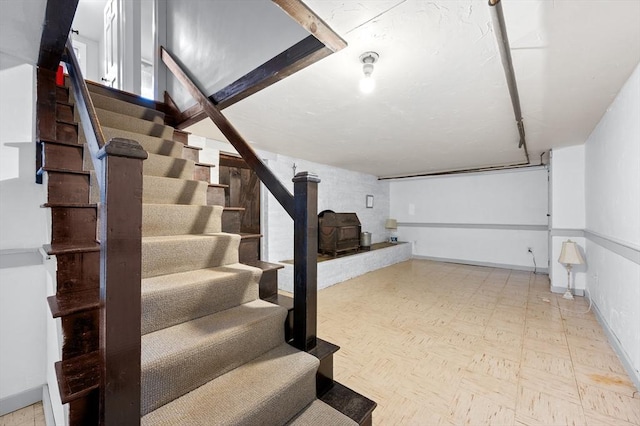 below grade area featuring stairs, baseboards, and tile patterned floors