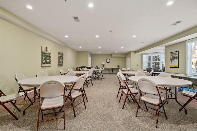 dining space featuring light carpet