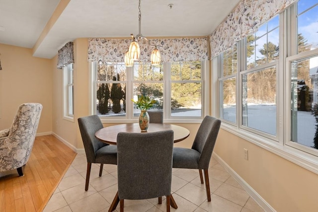 dining room with a healthy amount of sunlight, a chandelier, and light tile patterned flooring